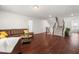 Open living room with hardwood floors, staircase, and comfortable brown leather sofa at 1321 White Spruce Dr, Willow Springs, NC 27592