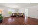 Bright living room features hardwood floors, a brown leather couch, and a large window at 1321 White Spruce Dr, Willow Springs, NC 27592