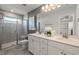 Modern bathroom features dual sinks, quartz countertops, and a glass-enclosed shower with gray tiling at 1472 Hasse Ave, Apex, NC 27502