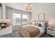 Cozy bedroom with a brown and blue color palette, featuring a window view and a wicker light fixture at 1472 Hasse Ave, Apex, NC 27502