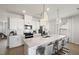 Well-lit kitchen showcasing white cabinets, stainless steel appliances and large center island at 1472 Hasse Ave, Apex, NC 27502