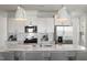 Modern kitchen featuring white cabinets, stainless steel appliances, and a quartz countertop island at 1472 Hasse Ave, Apex, NC 27502