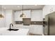 Bright kitchen featuring white cabinetry, quartz countertops, stylish pendant lighting, and stainless appliances at 154 Beacon Dr, Pittsboro, NC 27312