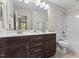 Well-lit bathroom with a double vanity, ample storage, and shower-tub combination at 1705 Bodwin Ln, Apex, NC 27502