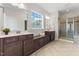 Elegant bathroom with double vanities, a bench, and a glass-enclosed shower at 1705 Bodwin Ln, Apex, NC 27502