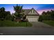 Charming single-story home with a well-manicured lawn, attached garage, and inviting curb appeal at twilight at 1705 Bodwin Ln, Apex, NC 27502