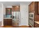 Kitchen featuring stainless steel refrigerator, built-in microwave and oven, and wooden cabinets at 1705 Bodwin Ln, Apex, NC 27502