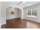Inviting living room showcasing hardwood floors, elegant wainscoting, and an arched doorway at 1705 Bodwin Ln, Apex, NC 27502