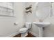 Cozy powder room featuring a pedestal sink, modern toilet, and stylish decor at 1705 Bodwin Ln, Apex, NC 27502