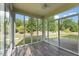 Sunroom with walls of windows offering serene backyard views and wood-look flooring at 1705 Bodwin Ln, Apex, NC 27502