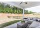 Cozy covered back porch with comfortable seating, ceiling fan, and a view of the fenced backyard at 181 Churchill Way, Clayton, NC 27520