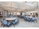 Spacious dining room featuring multiple tables with blue chairs and elegant chandelier lighting at 181 Churchill Way, Clayton, NC 27520