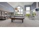 Large game room with pool tables, multiple seating areas, and expansive windows at 181 Churchill Way, Clayton, NC 27520
