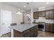 Well-lit kitchen showcasing a center island with seating, stainless steel appliances, and ample cabinet space at 181 Churchill Way, Clayton, NC 27520