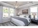 Cozy main bedroom with large windows, stylish lighting, and a comfortable upholstered bed at 181 Churchill Way, Clayton, NC 27520