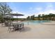 Community pool with plenty of seating under umbrellas and mature shade trees in the background on a clear day at 181 Churchill Way, Clayton, NC 27520