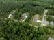 Aerial view of homes nestled in a lush, green wooded area at 190 Whistlers Cv, Louisburg, NC 27549