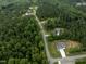Birds eye view of a well-planned community surrounded by dense trees and winding roads, featuring manicured lawns at 190 Whistlers Cv, Louisburg, NC 27549
