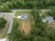 An aerial perspective reveals a charming home nestled among tall trees, with a driveway and expansive yard at 190 Whistlers Cv, Louisburg, NC 27549