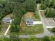 An aerial view showcasing a modern home, long driveway, and lush green surroundings in a rural community at 190 Whistlers Cv, Louisburg, NC 27549