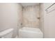 Tiled bathroom showcases a tub with shower and neutral earth-toned accents at 190 Whistlers Cv, Louisburg, NC 27549