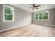 Bedroom with ample natural light from several windows, neutral walls, and wood-look floors at 190 Whistlers Cv, Louisburg, NC 27549