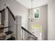 Grand entryway staircase with dark metal railings, white trim, and a stylish chandelier at 190 Whistlers Cv, Louisburg, NC 27549