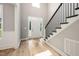Bright foyer with staircase, white trim, and wood-look flooring provides a welcoming entrance at 190 Whistlers Cv, Louisburg, NC 27549