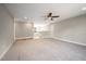 Open-concept living room with neutral carpet, ceiling fan, and staircase with natural light at 190 Whistlers Cv, Louisburg, NC 27549