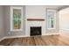 Living room featuring a fireplace with white shiplap and a wood mantel, plus two large windows at 190 Whistlers Cv, Louisburg, NC 27549