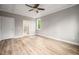 Spacious bedroom featuring hardwood floors, tray ceiling, ceiling fan, and ensuite bathroom entrance at 190 Whistlers Cv, Louisburg, NC 27549