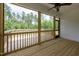 Screened porch with wood floors and ceiling fan that overlooks a green forest at 190 Whistlers Cv, Louisburg, NC 27549