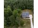 Stunning aerial perspective of a home with a long driveway surrounded by a dense canopy of trees at 200 Whistlers Cv, Louisburg, NC 27549