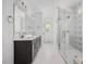 Bright bathroom featuring a double vanity and glass-enclosed shower with decorative tiling at 200 Whistlers Cv, Louisburg, NC 27549