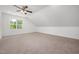 Bedroom features a window allowing natural light, ceiling fan, and neutral carpeting at 200 Whistlers Cv, Louisburg, NC 27549