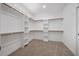 Bright, walk-in closet with custom shelves and hanging rods for optimal storage at 200 Whistlers Cv, Louisburg, NC 27549