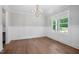 Empty dining room space with modern chandelier, wainscotting and oversized window at 200 Whistlers Cv, Louisburg, NC 27549
