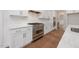 Gourmet kitchen featuring stainless steel appliances, quartz countertops, tile backsplash, and modern white cabinetry at 200 Whistlers Cv, Louisburg, NC 27549