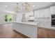 Bright, open kitchen with white cabinetry, stainless steel appliances, and a large central island at 200 Whistlers Cv, Louisburg, NC 27549
