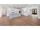Open kitchen with white cabinets, an island with seating, hardwood floors, and modern lighting at 200 Whistlers Cv, Louisburg, NC 27549