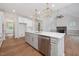Kitchen island with stainless steel appliances, quartz countertops, modern lighting, and an open-concept design at 200 Whistlers Cv, Louisburg, NC 27549