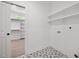 Bright laundry room featuring decorative tile flooring and functional shelving for storage at 200 Whistlers Cv, Louisburg, NC 27549