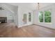 Open-concept area with hardwood floors, modern lighting, large windows, and a fireplace at 200 Whistlers Cv, Louisburg, NC 27549