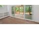 View of a covered porch through sliding glass doors, featuring wooden railings and a concrete floor at 200 Whistlers Cv, Louisburg, NC 27549