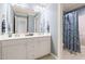 Bathroom featuring double sinks, white cabinets, and a shower/tub combo at 204 Towne Ridge Ln, Chapel Hill, NC 27516