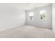 Bright bedroom features neutral carpet, two windows, and white trim at 204 Towne Ridge Ln, Chapel Hill, NC 27516