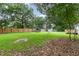 Backyard features large lawn, fence, shed, mature trees and deck at 204 Valley Ct, Selma, NC 27576