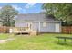 Backyard with deck, gray siding and manicured lawn at 204 Valley Ct, Selma, NC 27576