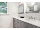 Bathroom features double sink vanity, gray cabinets, white counters, and white walls at 204 Valley Ct, Selma, NC 27576