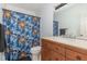 Cozy bathroom featuring single sink vanity with storage and colorful shower curtain at 204 Valley Ct, Selma, NC 27576